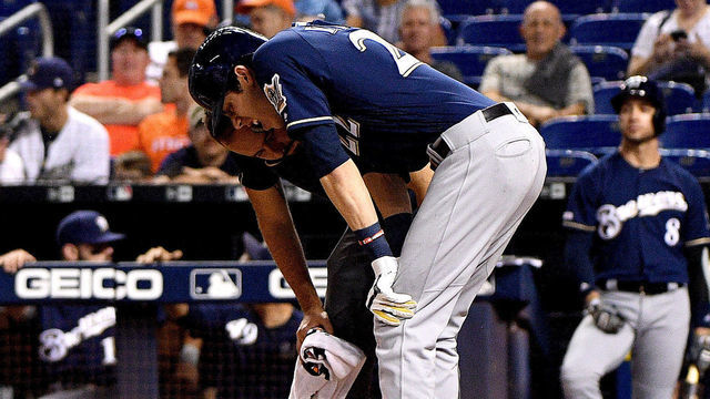 MIAMI, FLORIDA - SEPTEMBER 10: Christian Yelich #22 of the Milwaukee Brewers is checked out by the medical staff after an injury from ball deflection in the first inning against the Miami Marlins at Marlins Park on September 10, 2019 in Miami, Florida.