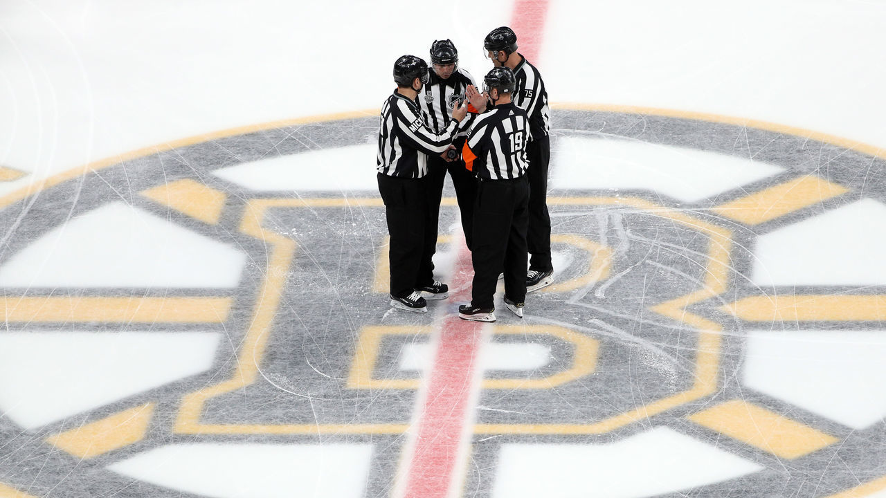 BOSTON, MASSACHUSETTS - JUNE 12: The referees meet at mid-ice prior to Game Seven of the 2019 NHL Stanley Cup Final between the Boston Bruins and the St. Louis Blues at TD Garden on June 12, 2019 in Boston, Massachusetts.