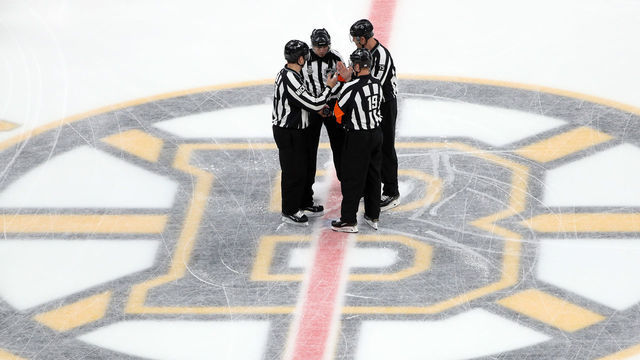 BOSTON, MASSACHUSETTS - JUNE 12: The referees meet at mid-ice prior to Game Seven of the 2019 NHL Stanley Cup Final between the Boston Bruins and the St. Louis Blues at TD Garden on June 12, 2019 in Boston, Massachusetts.
