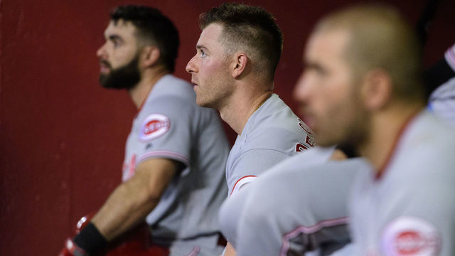 PHOENIX, ARIZONA - SEPTEMBER 14: Anthony DeSclafani #28 of the Cincinnati Reds sits in between Jose Peraza #9 (L) and Joey Votto #19 (R) during the MLB game against the Arizona Diamondbacks at Chase Field on September 14, 2019 in Phoenix, Arizona.