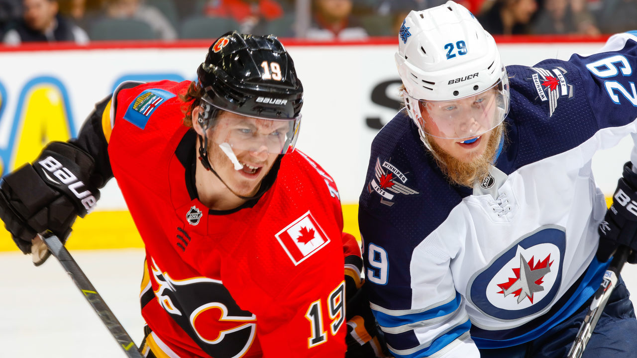 CALGARY, AB - JANUARY 20: Matthew Tkachuk #19 of the Calgary Flames and Patrik Laine #29 of the Winnipeg Jets at face off in an NHL game on January 20, 2018 at the Scotiabank Saddledome in Calgary, Alberta, Canada.
