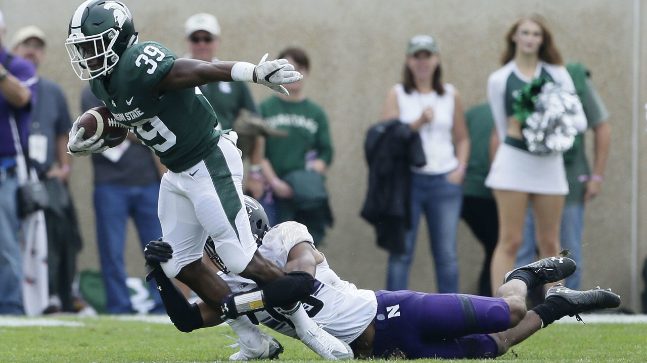 EAST LANSING, MI - OCTOBER 6: Running back Alante Thomas #39 of the Michigan State Spartans is tackled by defensive back JR Pace #13 of the Northwestern Wildcats during the second half at Spartan Stadium on October 6, 2018 in East Lansing, Michigan. Northwestern defeated Michigan State 29-19.