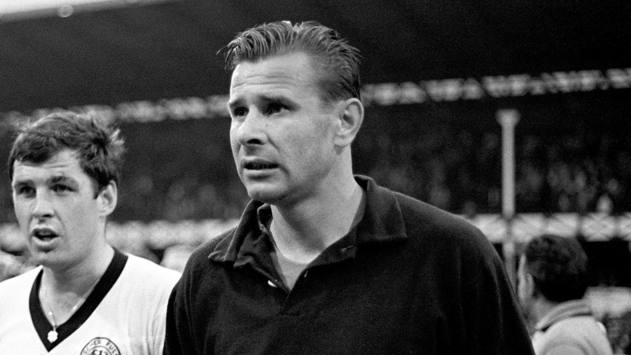 West Germany's Lothar Emmerich (l) leaves the pitch with USSR goalkeeper Lev Yashin (r) after the match