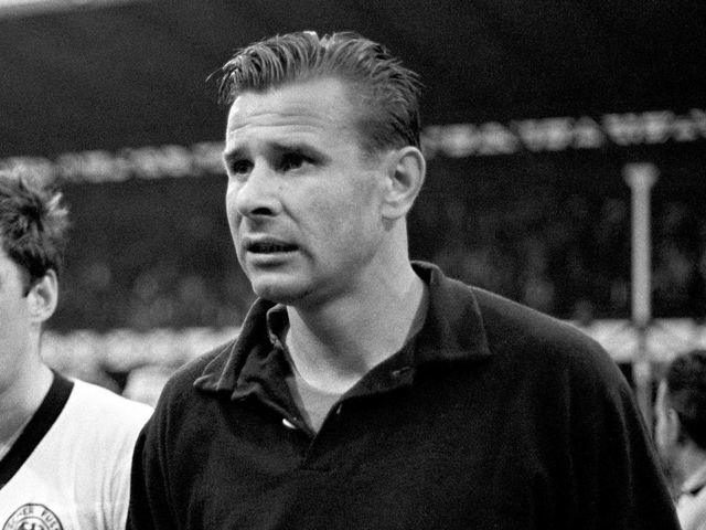 West Germany's Lothar Emmerich (l) leaves the pitch with USSR goalkeeper Lev Yashin (r) after the match