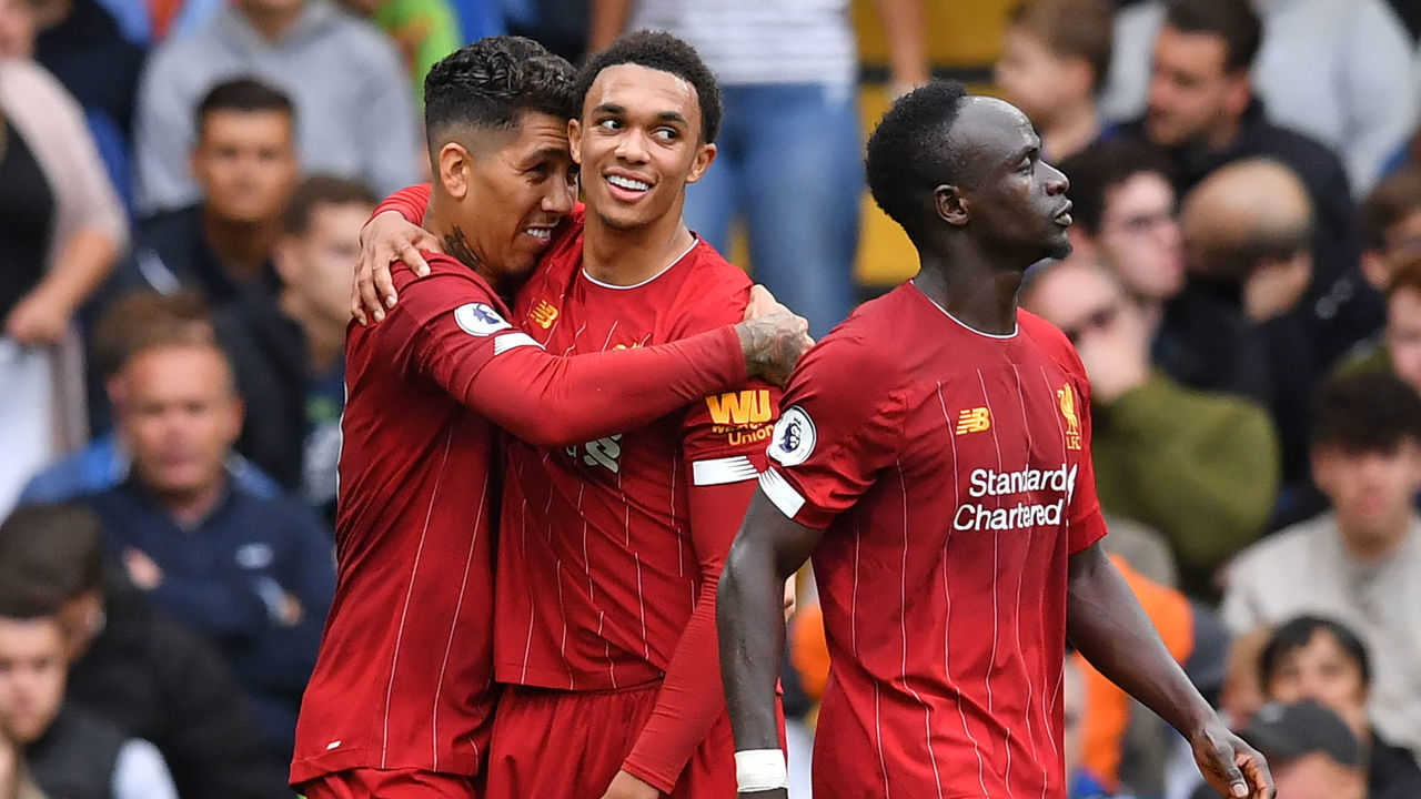 Liverpool's Brazilian midfielder Roberto Firmino (L) celebrates with Liverpool's English defender Trent Alexander-Arnold (C) after scoring their second goal during the English Premier League football match between Chelsea and Liverpool at Stamford Bridge in London on September 22, 2019.