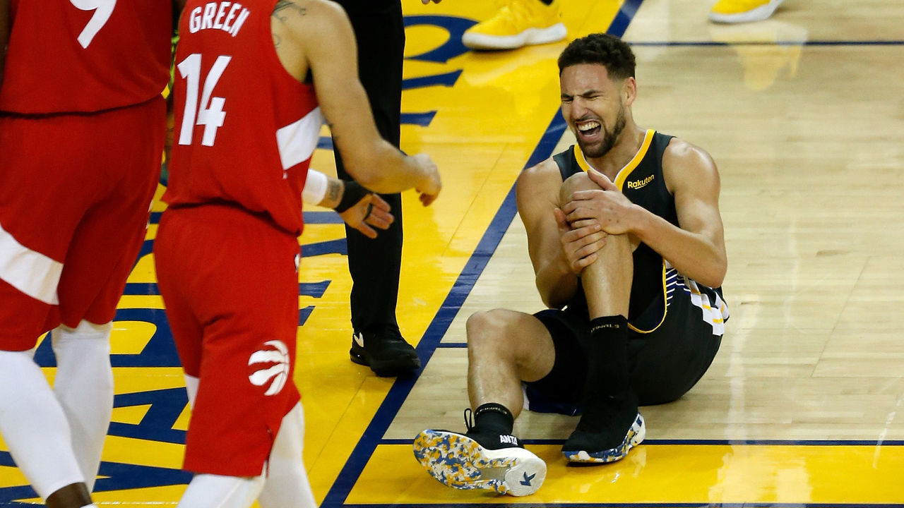 OAKLAND, CALIFORNIA - JUNE 13: Klay Thompson #11 of the Golden State Warriors reacts after hurting his leg against the Toronto Raptors in the second half during Game Six of the 2019 NBA Finals at ORACLE Arena on June 13, 2019 in Oakland, California.