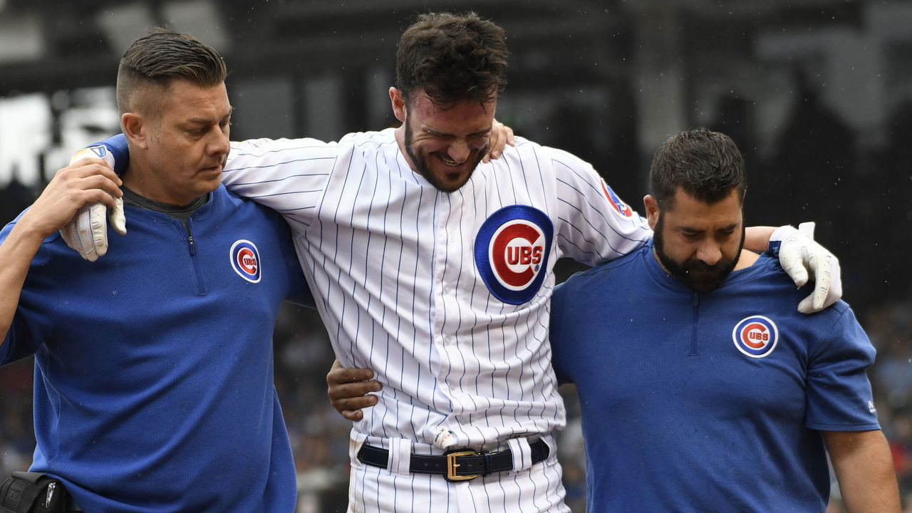 CHICAGO, ILLINOIS - SEPTEMBER 22: Kris Bryant #17 of the Chicago Cubs is helped off the field by trainers after hurting him self running to first base against the St. Louis Cardinals during the third inning at Wrigley Field on September 22, 2019 in Chicago, Illinois.