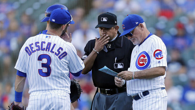 CHICAGO, ILLINOIS - SEPTEMBER 14: Manager Joe Maddon #70 of the Chicago Cubs stands on the mound after Dillon Maples #36 was removed by umpire Alfonso Marquez #72 during the ninth inning of a game against the Pittsburgh Pirates at Wrigley Field on September 14, 2019 in Chicago, Illinois.