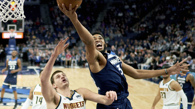 MINNEAPOLIS, MN - NOVEMBER 21: Karl-Anthony Towns #32 of the Minnesota Timberwolves shoots the ball against Nikola Jokic #15 of the Denver Nuggets during the game on November 21, 2018 at the Target Center in Minneapolis, Minnesota.