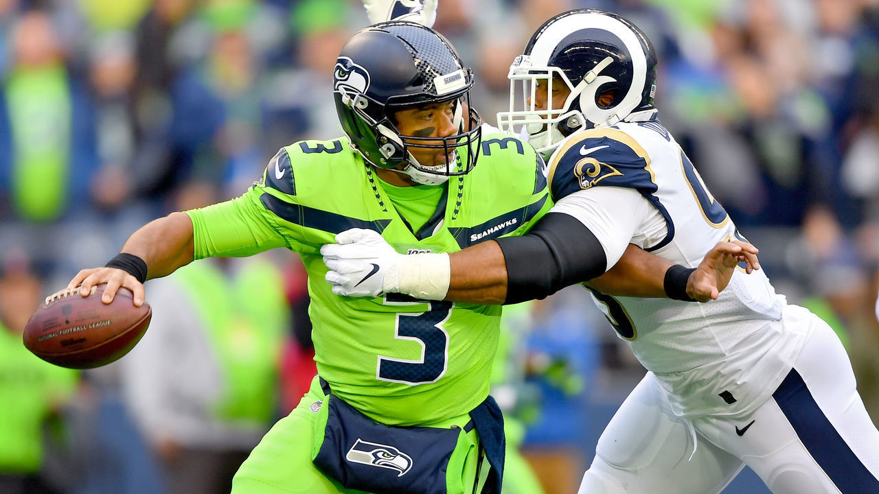 SEATTLE, WASHINGTON - OCTOBER 03: Russell Wilson #3 of the Seattle Seahawks is pressured by Aaron Donald #99 of the Los Angeles Rams during the first half of the game at CenturyLink Field on October 03, 2019 in Seattle, Washington.