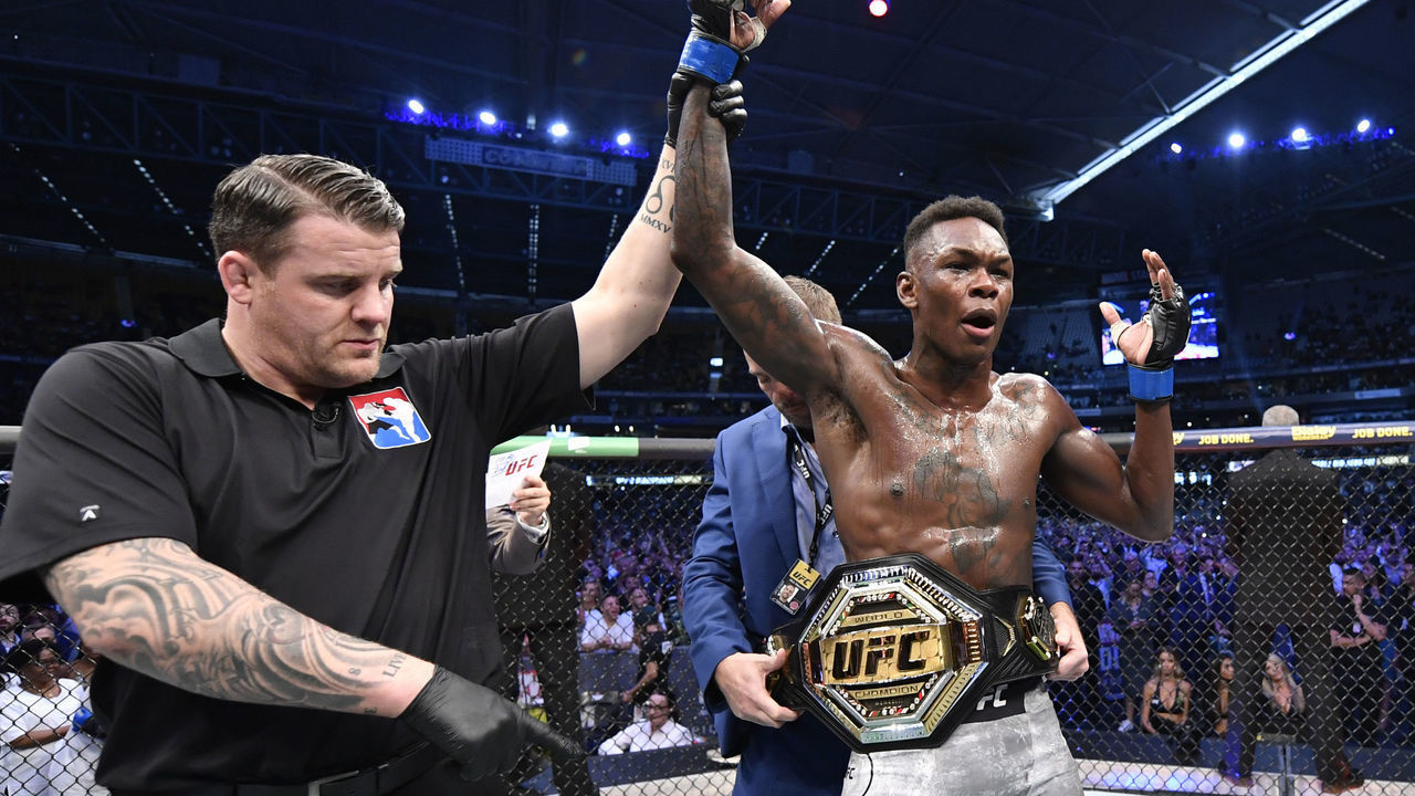 MELBOURNE, AUSTRALIA - OCTOBER 06: Israel Adesanya of Nigeria celebrates after his knockout victory over Robert Whittaker of New Zealand in their UFC middleweight championship fight during the UFC 243 event at Marvel Stadium on October 06, 2019 in Melbourne, Australia.