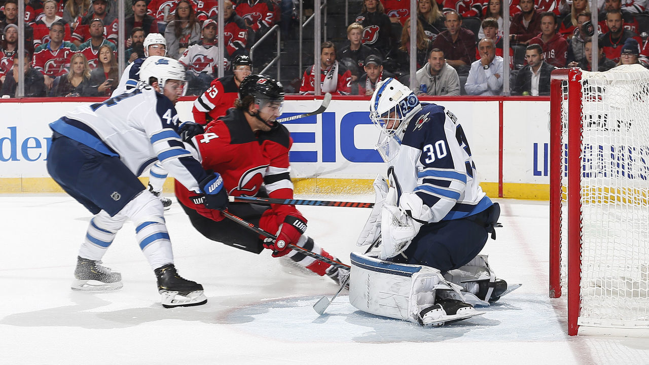 NEWARK, NJ- October 04: Laurent Brossoit #30 of the Winnipeg Jets defends the net against Miles Wood #44 of the New Jersey Devils on October 4, 2019 at Prudential Center in Newark, New Jersey. The Jets defeated the Devils 5-4 in a shoot out.