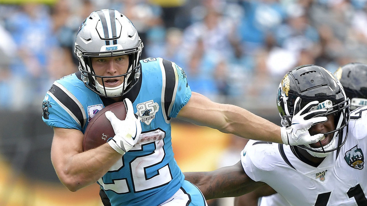 CHARLOTTE, NORTH CAROLINA - OCTOBER 06: Christian McCaffrey #22 of the Carolina Panthers stiff-arms Josh Allen #41 of the Jacksonville Jaguars during the second half of their game at Bank of America Stadium on October 06, 2019 in Charlotte, North Carolina. The Panthers won 34-27.