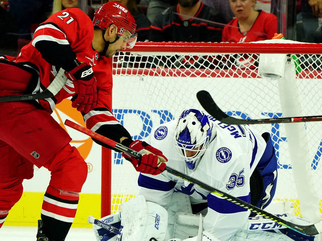 RALEIGH, NC - OCTOBER 6: Curtis McElhinney #35 of the Tampa Bay Lightning goes down in the crease to make the stop as Nino Niederreiter #21 attempts to deflect the puck into the net during an NHL game on October 6, 2019 at PNC Arena in Raleigh North Carolina.