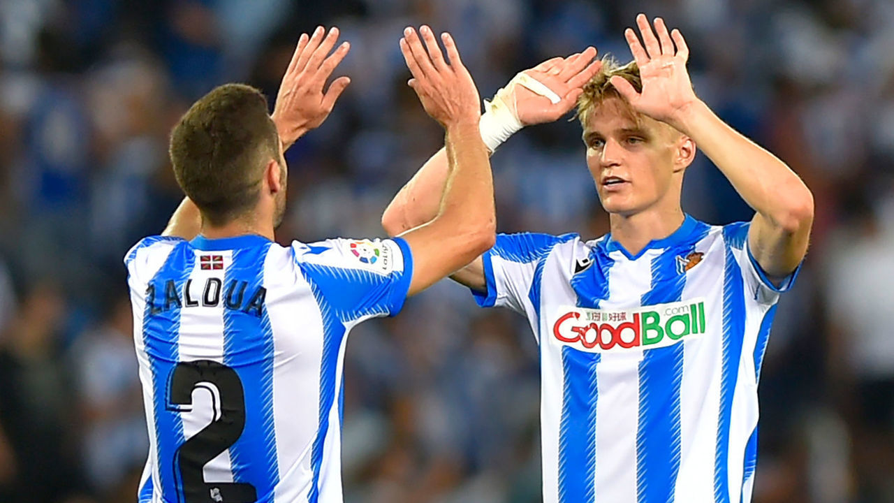 Real Sociedad's Norwegian midfielder Martin Odegaard (R) and Real Sociedad's Spanish defender Joseba Zaldua celebrate victory at the end of the Spanish league football match Real Sociedad against Club Atletico de Madrid at The Anoeta Stadium in San Sebastian on September 14, 2019.