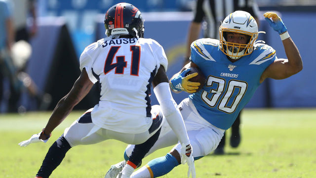 CARSON, CALIFORNIA - OCTOBER 06: DeVante Bausby #41 of the Denver Broncos defends against the run of Austin Ekeler #30 of the Los Angeles Chargers during the first half of a game at Dignity Health Sports Park on October 06, 2019 in Carson, California.