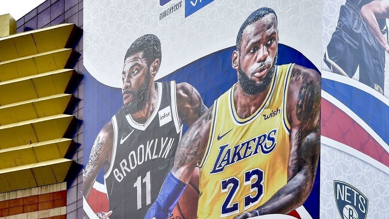 SHANGHAI, CHINA - OCTOBER 09: A worker removes a large poster from a building ahead of NBA Shanghai Game 2019 between Brooklyn Nets and Los Angeles Lakers at the Lujiazui Zhengda Plaza on October 9, 2019 in Shanghai, China.