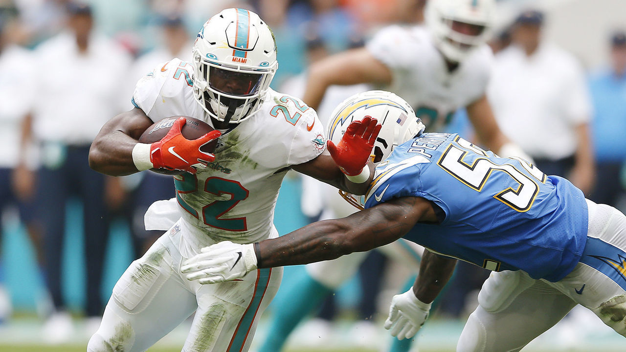 MIAMI, FLORIDA - SEPTEMBER 29: Mark Walton #22 of the Miami Dolphins is tackled by Denzel Perryman #52 of the Los Angeles Chargers during the second quarter at Hard Rock Stadium on September 29, 2019 in Miami, Florida.