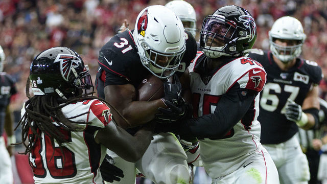 GLENDALE, ARIZONA - OCTOBER 13: Running back David Johnson #31 of the Arizona Cardinals carries the ball against defensive back Kemal Ishmael #36 and linebacker Deion Jones #45 of the Atlanta Falcons in the first half of the NFL game at State Farm Stadium on October 13, 2019 in Glendale, Arizona.