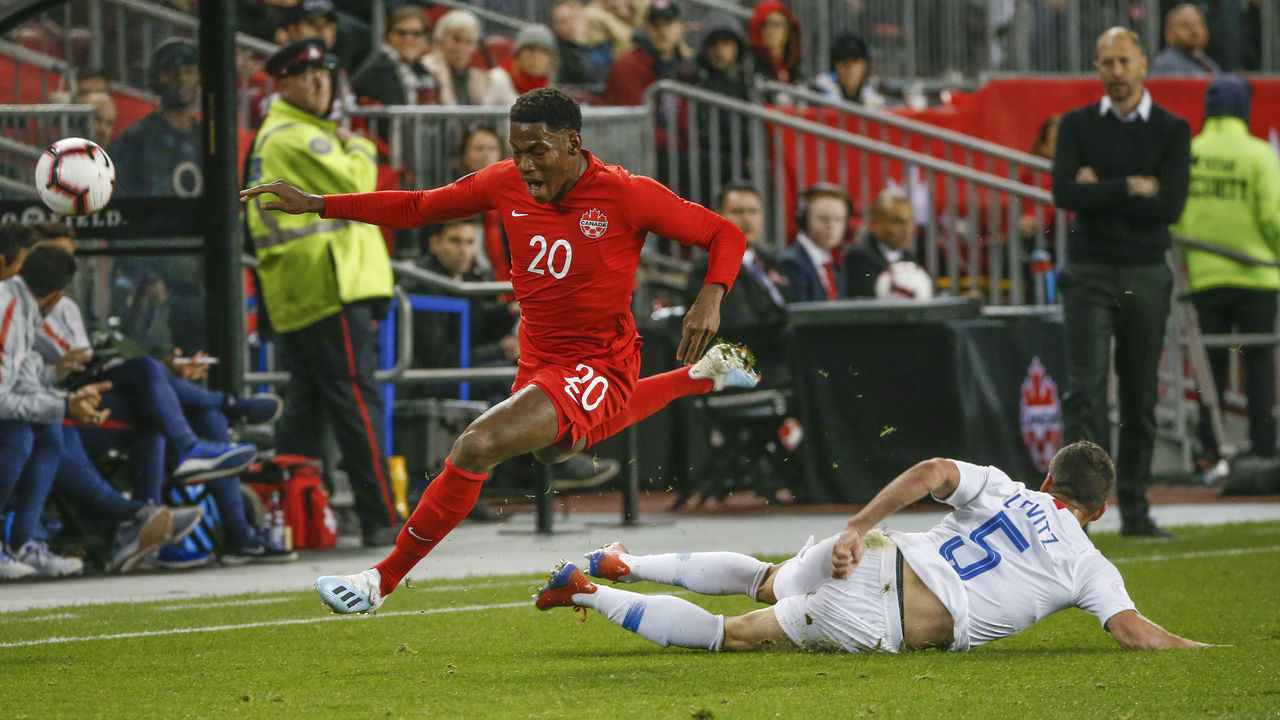 TORONTO, ON - OCTOBER 15: Canada forward Jonathan David (20) leaps over the United States defender Daniel Lovitz (5). Canada vs USA during 1st half action in CONCACAF Nations League A play at BMO Field. Toronto Star/Rick Madonik (Rick Madonik/Toronto Star via Getty Images)