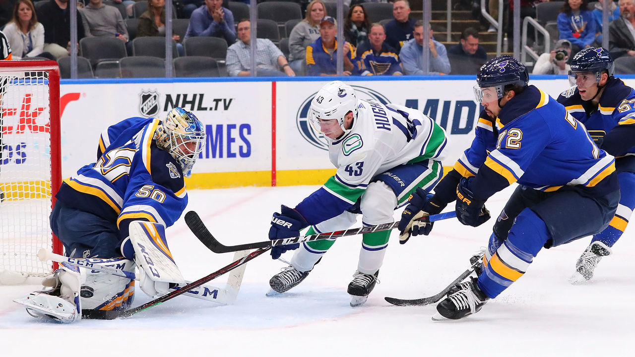 ST LOUIS, MO - OCTOBER 17: Jordan Binnington #50 of the St. Louis Blues makes a save against Quinn Hughes #43 of the Vancouver Canucks as Justin Faulk #72 of the St. Louis Blues defends at Enterprise Center on October 17, 2019 in St Louis, Missouri.