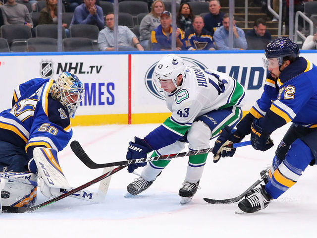 ST LOUIS, MO - OCTOBER 17: Jordan Binnington #50 of the St. Louis Blues makes a save against Quinn Hughes #43 of the Vancouver Canucks as Justin Faulk #72 of the St. Louis Blues defends at Enterprise Center on October 17, 2019 in St Louis, Missouri.