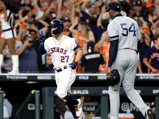 HOUSTON, TEXAS - OCTOBER 19: Jose Altuve #27 of the Houston Astros comes home to score following his ninth inning walk-off two-run home run as Aroldis Chapman #54 of the New York Yankees walks off the field in game six of the American League Championship Series at Minute Maid Park on October 19, 2019 in Houston, Texas. The Astros defeated the Yankees 6-4.