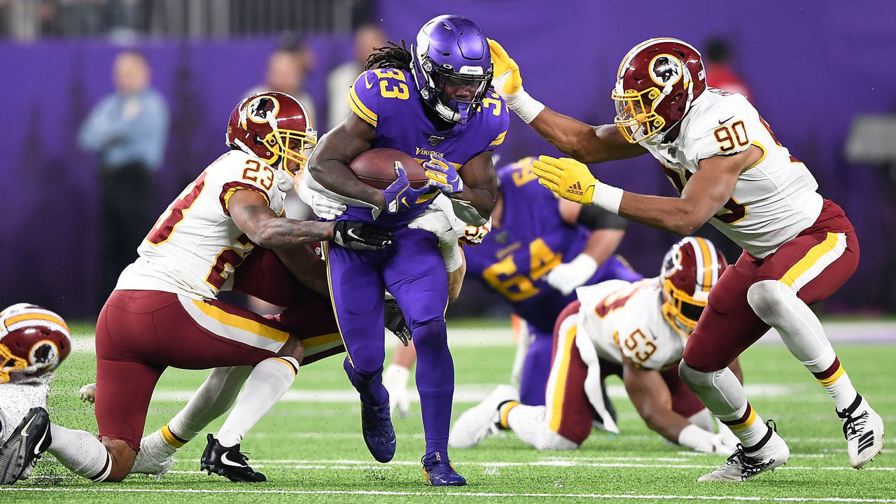 MINNEAPOLIS, MINNESOTA - OCTOBER 24: Running back Dalvin Cook #33 of the Minnesota Vikings runs against the defense of Montez Sweat #90 and Quinton Dunbar #23 of the Washington Redskins in the game at U.S. Bank Stadium on October 24, 2019 in Minneapolis, Minnesota.