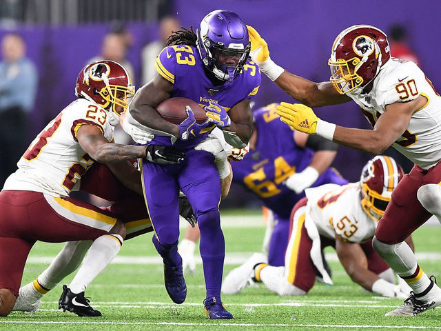 MINNEAPOLIS, MINNESOTA - OCTOBER 24: Running back Dalvin Cook #33 of the Minnesota Vikings runs against the defense of Montez Sweat #90 and Quinton Dunbar #23 of the Washington Redskins in the game at U.S. Bank Stadium on October 24, 2019 in Minneapolis, Minnesota.