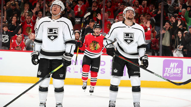CHICAGO, IL - OCTOBER 27: Tyler Toffoli #73 and Adrian Kempe #9 of the Los Angeles Kings react as Alex DeBrincat #12 of the Chicago Blackhawks celebrates in the background after scoring in the second period at the United Center on October 27, 2019 in Chicago, Illinois.