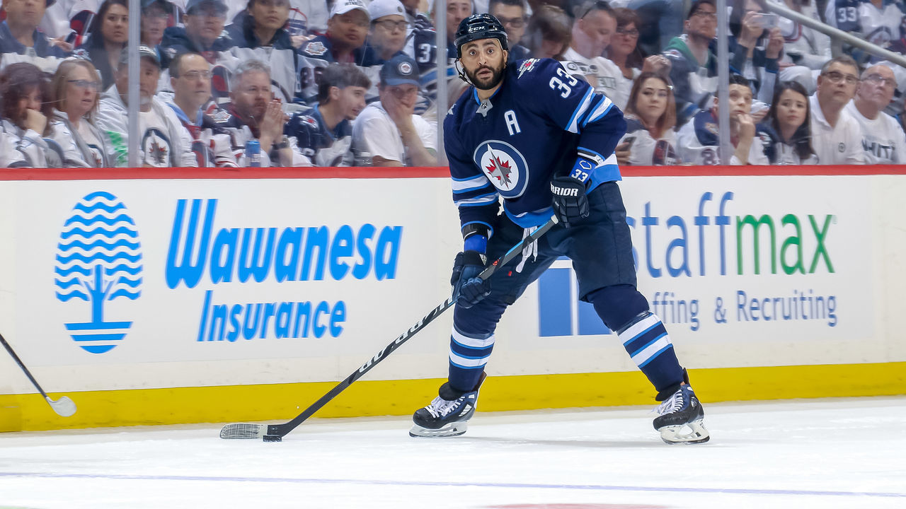 WINNIPEG, MB - APRIL 18: Dustin Byfuglien #33 of the Winnipeg Jets plays the puck down the ice during second period action against the St. Louis Blues in Game Five of the Western Conference First Round during the 2019 NHL Stanley Cup Playoffs at the Bell MTS Place on April 18, 2019 in Winnipeg, Manitoba, Canada. The Blues defeated the Jets 3-2 to lead the series 3-2.