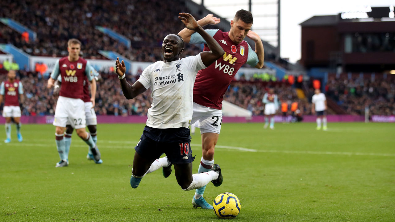 Liverpool's Sadio Mane goes down in the area under the challenge from Aston Villa's Frederic Guilbert and is booked for diving during the Premier League match at Villa Park, Birmingham.
