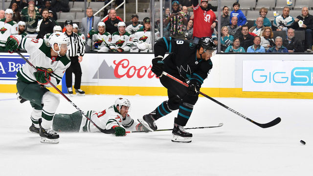 SAN JOSE, CA - NOVEMBER 07: Evander Kane #9 of the San Jose Sharks skates with the puck against Brad Hunt #77 and Carson Soucy #21 the Minnesota Wild at SAP Center on November 7, 2019 in San Jose, California.