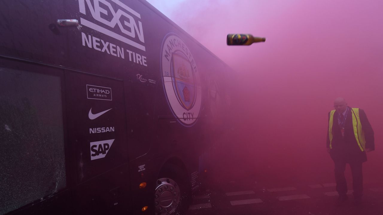 TOPSHOT - Bottles and cans are thrown at the bus as Manchester City players arrive at the stadium before the UEFA Champions League first leg quarter-final football match between Liverpool and Manchester City, at Anfield stadium in Liverpool, north west England on April 4, 2018. / AFP PHOTO / Paul ELLIS