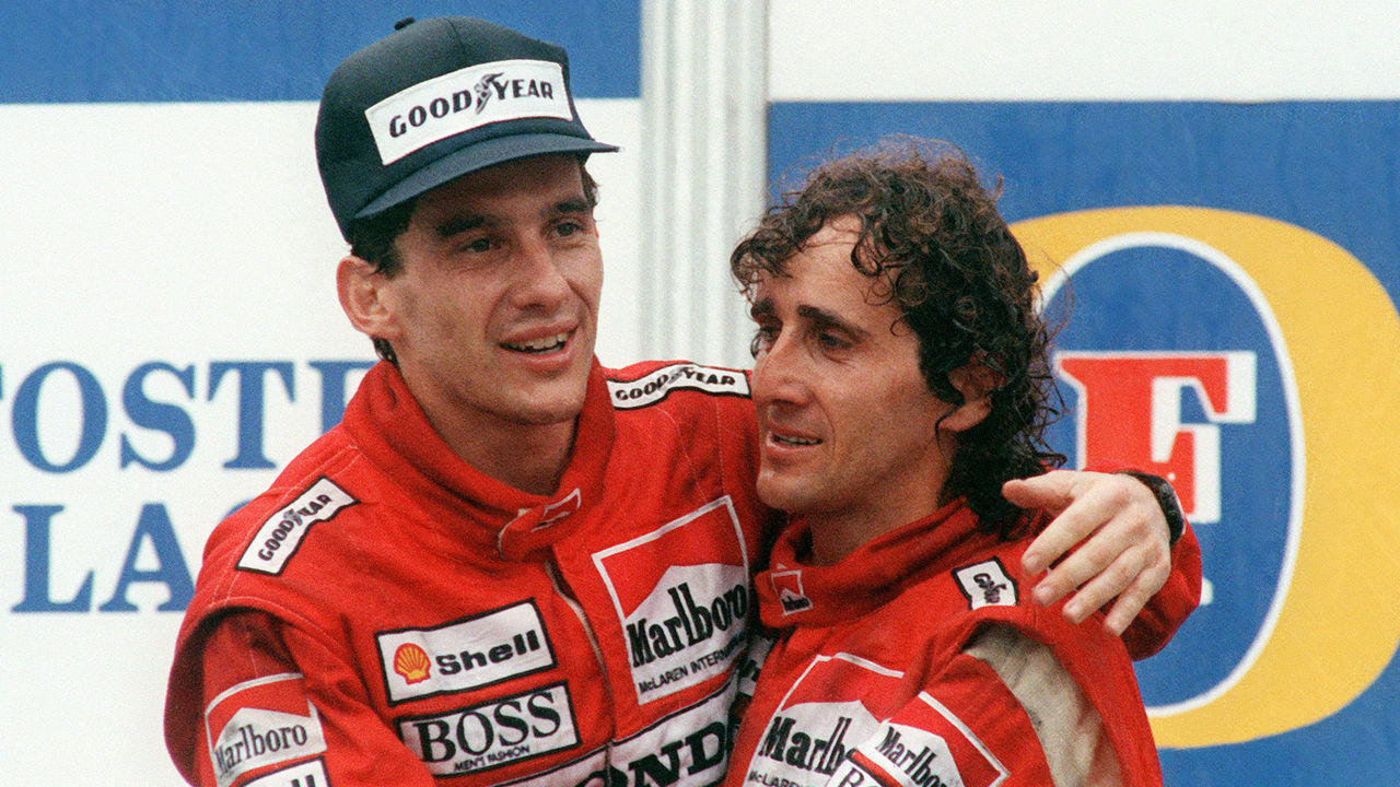 Brazilian new formula one champion Ayrton Senna (L) embraces his teammate and winner of today Adelaide Australian Grand Prix French driver Alain Prost on the podium 13 November 1988.