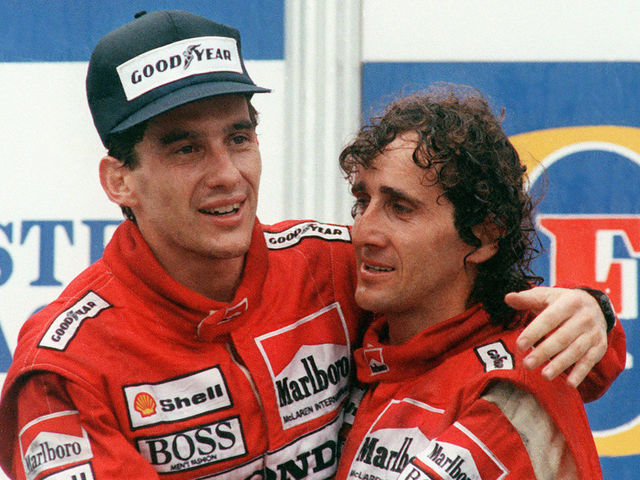 Brazilian new formula one champion Ayrton Senna (L) embraces his teammate and winner of today Adelaide Australian Grand Prix French driver Alain Prost on the podium 13 November 1988.