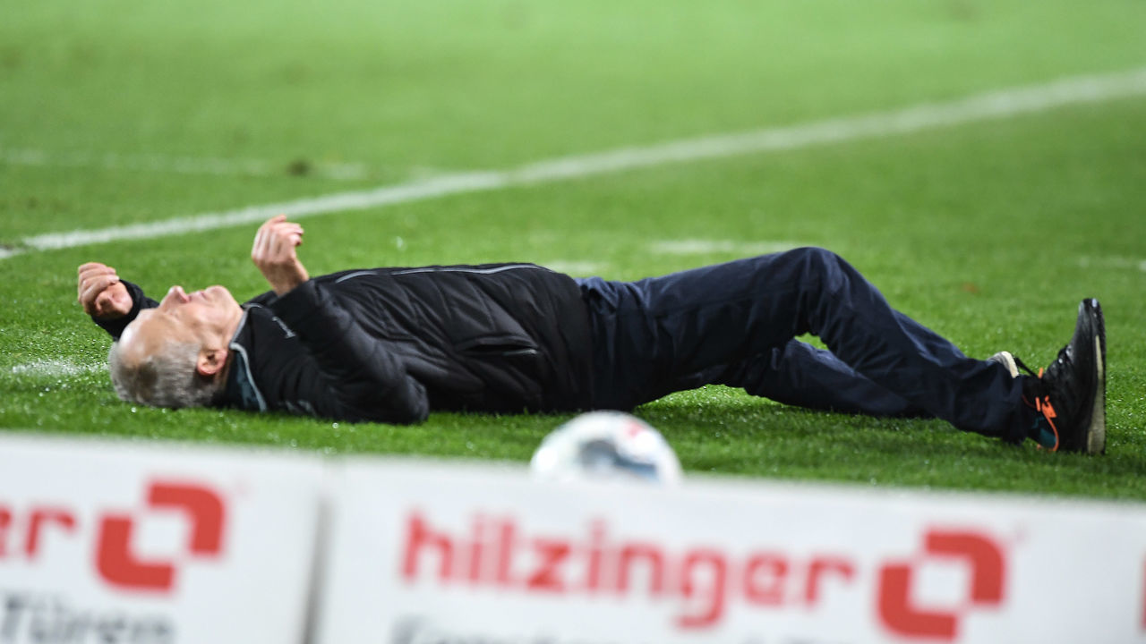 FREIBURG IM BREISGAU, GERMANY - NOVEMBER 10: Headcoach Christian Streich of SC Freiburg lying on pitch after a check during the Bundesliga match between Sport-Club Freiburg and Eintracht Frankfurt at Schwarzwald-Stadion on November 10, 2019 in Freiburg im Breisgau, Germany.