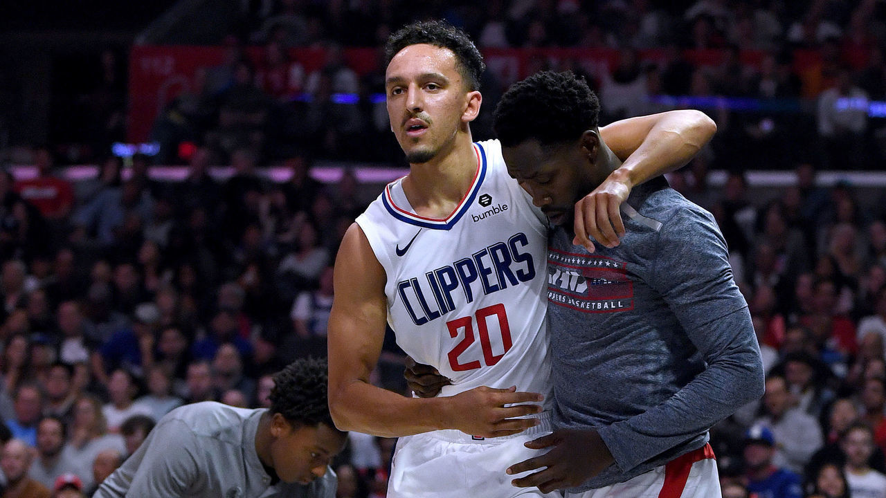 LOS ANGELES, CALIFORNIA - NOVEMBER 11: Landry Shamet #20 of the LA Clippers is helped off the court by Patrick Beverley #21 during a 98-88 Clippers win over the Toronto Raptors at Staples Center on November 11, 2019 in Los Angeles, California. NOTE TO USER: User expressly acknowledges and agrees that, by downloading and/or using this photograph, user is consenting to the terms and conditions of the Getty Images License Agreement.