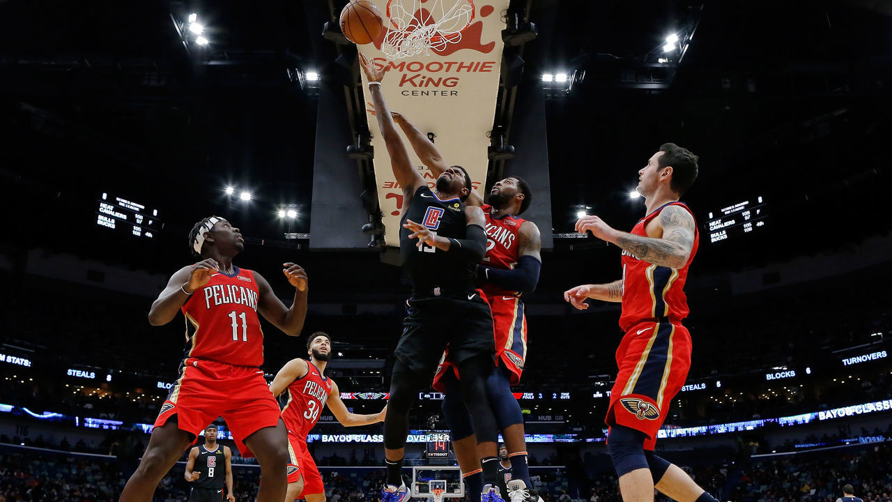 NEW ORLEANS, LOUISIANA - NOVEMBER 14: Paul George #13 of the LA Clippers scores as Derrick Favors #22 of the New Orleans Pelicans defends during the second half of a game at the Smoothie King Center on November 14, 2019 in New Orleans, Louisiana.