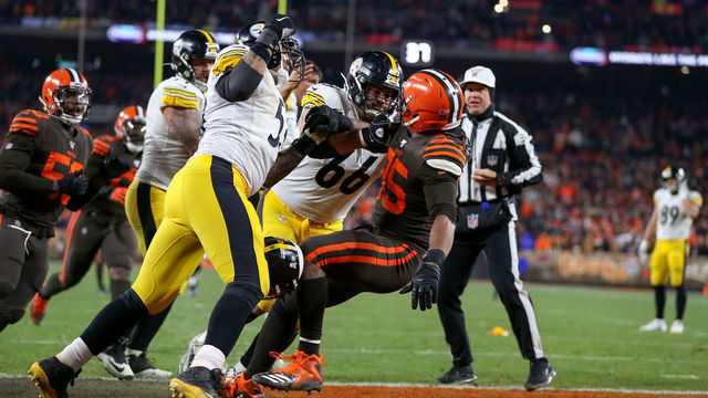 CLEVELAND, OH - NOVEMBER 14: Pittsburgh Steelers center Maurkice Pouncey (53) and Pittsburgh Steelers offensive guard David DeCastro (66) take down Cleveland Browns defensive end Myles Garrett (95) after Garrett hit Pittsburgh Steelers quarterback Mason Rudolph (2) (not pictured) with his own helmet with 0:08 seconds left in the fourth quarter of the National Football League game between the Pittsburgh Steelers and Cleveland Browns on November 14, 2019, at FirstEnergy Stadium in Cleveland, OH.