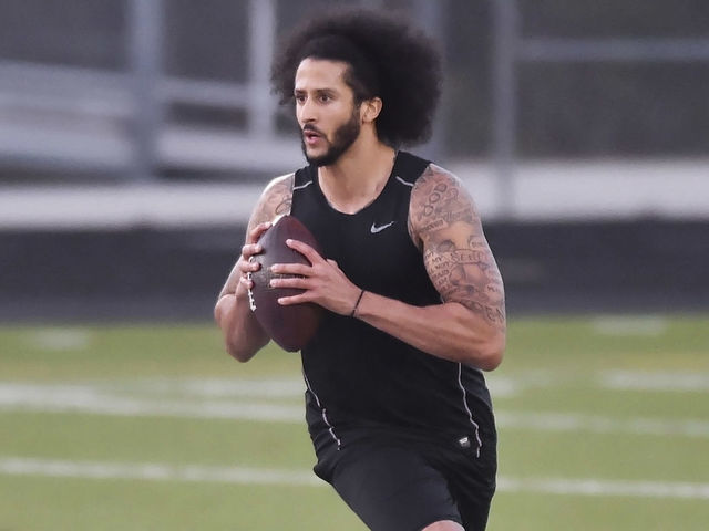 RIVERDALE, GA - NOVEMBER 16: Former NFL quarterback Colin Kaepernick rolls out while looking downfield while going through a series of passing drills at Southern Crescent Stadium at Charles R. Drew High School.