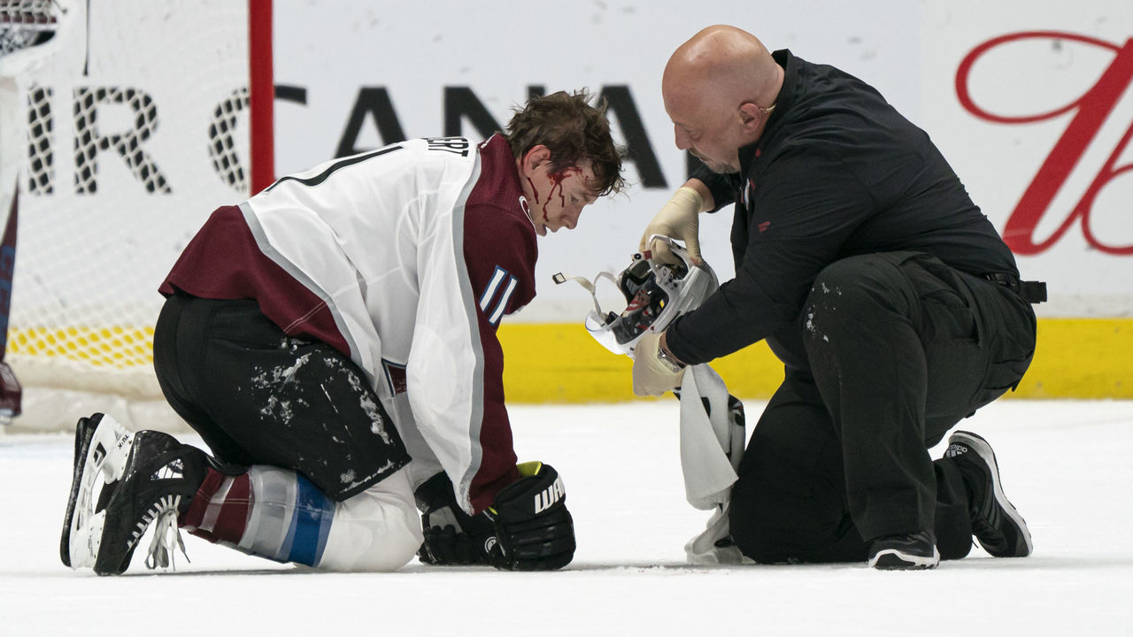 VANCOUVER, BC - NOVEMBER 16: Matt Calvert #11 of the Colorado Avalanche is attended to by a team trainer after getting hit with a shot during NHL action against the Vancouver Canucks at Rogers Arena on November 16, 2019 in Vancouver, Canada.