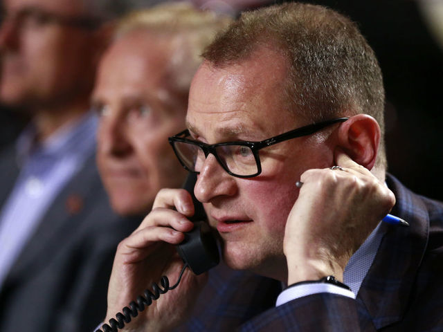 VANCOUVER, BRITISH COLUMBIA - JUNE 21: General manager Brad Treliving of the Calgary Flames talks on the phone from the team draft table during the first round of the 2019 NHL Draft at Rogers Arena on June 21, 2019 in Vancouver, Canada.
