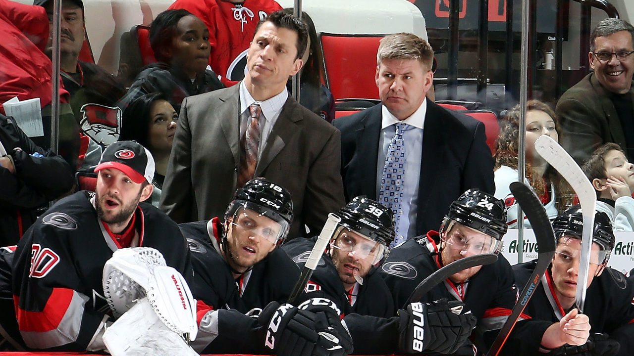 RALEIGH, NC - JANUARY 27:Assistant coach Rod Brind'Amour and Head Coach Bill Peters of the Carolina Hurricanes watch action on the ice as players Cam Ward #30, Jay McClement #18, Pat Dwyer #39, Brad Malone and Jeff Skinner #53 look on during their NHL game against the Tampa Bay Lightning at PNC Arena on January 27, 2015 in Raleigh, North Carolina.