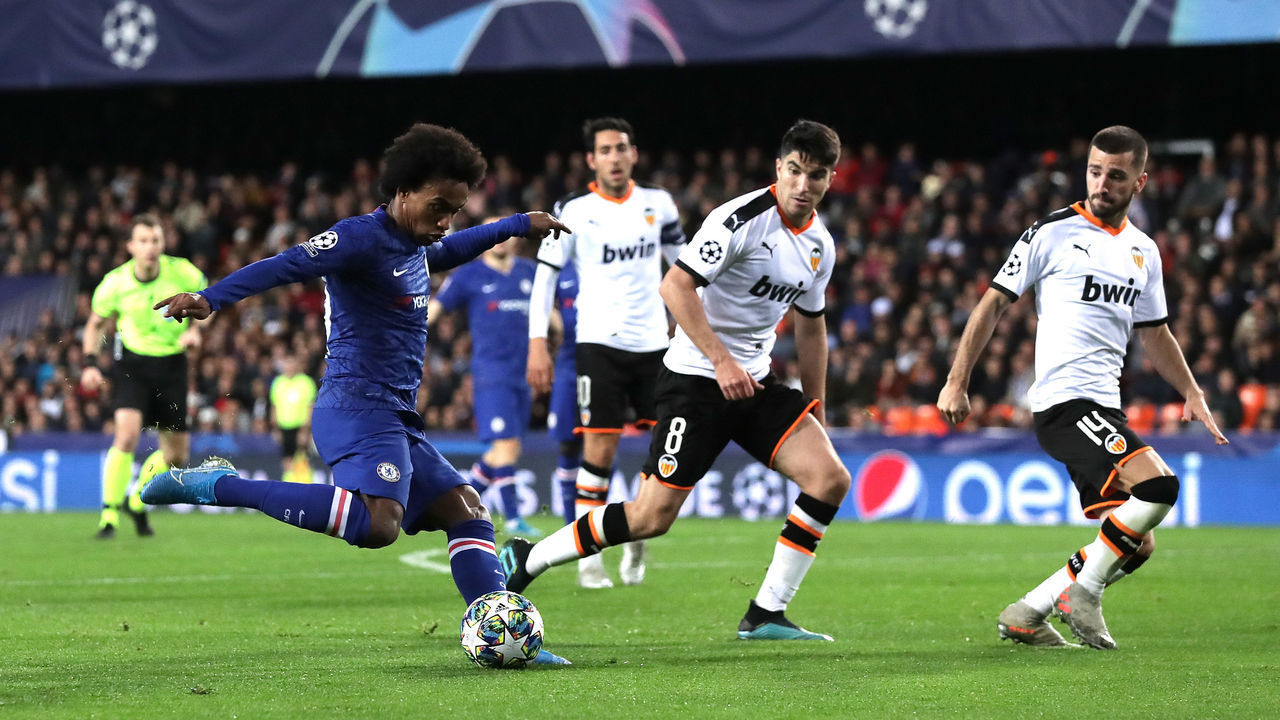 VALENCIA, SPAIN - NOVEMBER 27: Willian of Chelsea shoots under pressure from Carlos Soler and Jose Luis Gaya of Valencia during the UEFA Champions League group H match between Valencia CF and Chelsea FC at Estadio Mestalla on November 27, 2019 in Valencia, Spain.