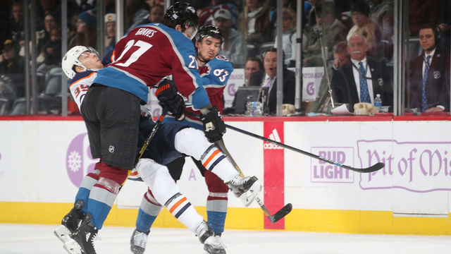 DENVER, COLORADO - NOVEMBER 27: Ryan Graves #27 of the Colorado Avalanche sends Alex Chiasson #39 of the Edmonton Oilers to the ice after an open ice hit at the Pepsi Center on November 27, 2019 in Denver, Colorado.