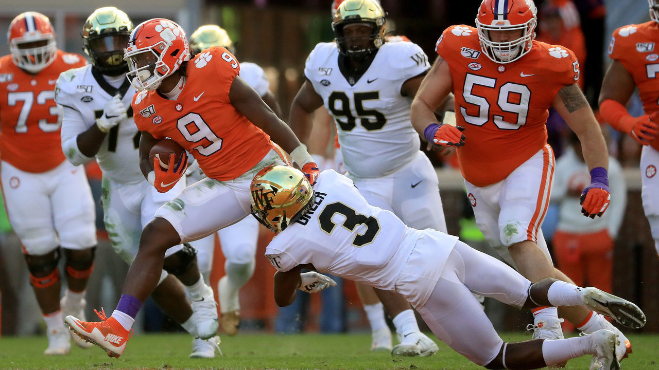 CLEMSON, SOUTH CAROLINA - NOVEMBER 16: Travis Etienne #9 of the Clemson Tigers tries to get away from Nasir Greer #3 of the Wake Forest Demon Deacons during their game at Memorial Stadium on November 16, 2019 in Clemson, South Carolina.