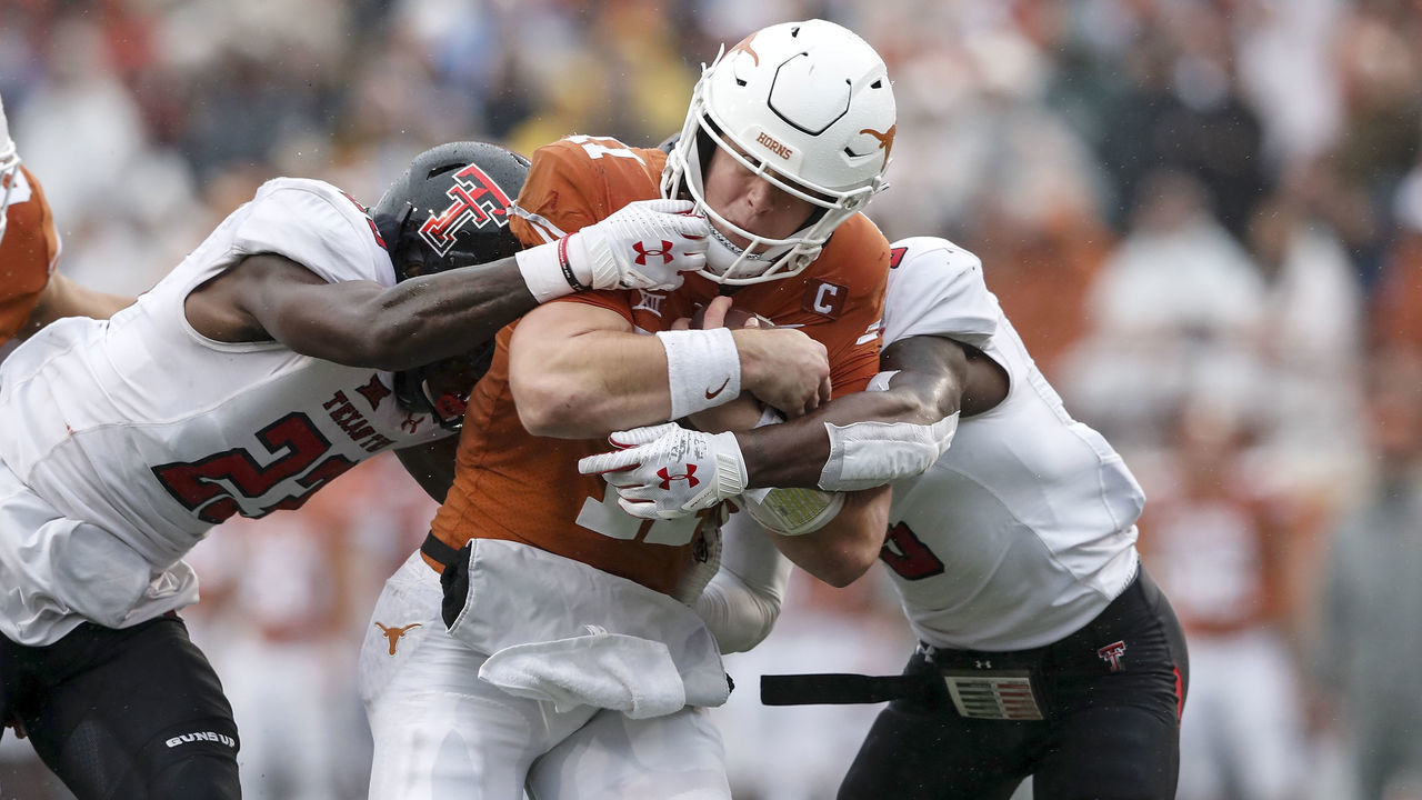 AUSTIN, TX - NOVEMBER 29: Sam Ehlinger #11 of the Texas Longhorns is tackled by the facemask by Damarcus Fields #23 of the Texas Tech Red Raiders in the second quarter at Darrell K Royal-Texas Memorial Stadium on November 29, 2019 in Austin, Texas.