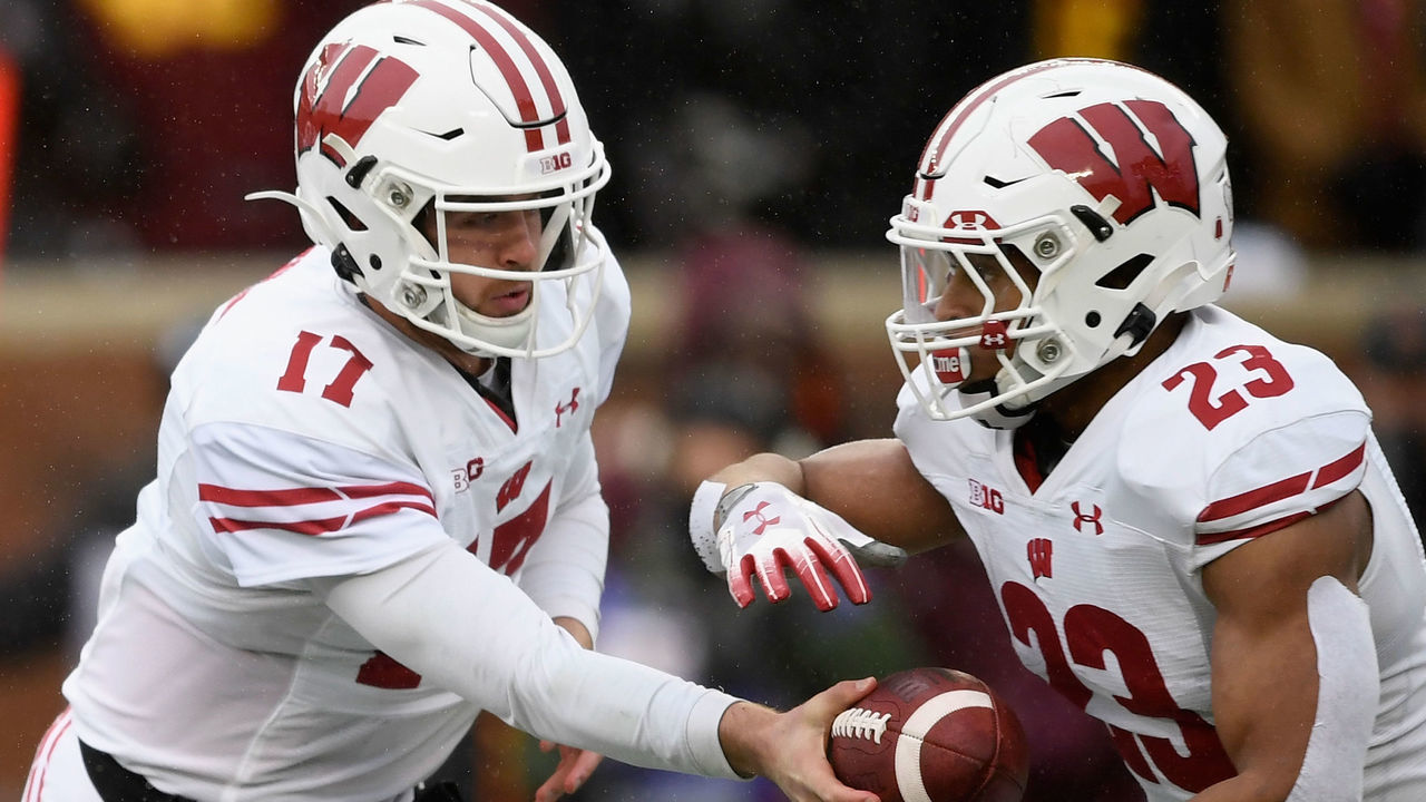 MINNEAPOLIS, MINNESOTA - NOVEMBER 30: Jack Coan #17 of the Wisconsin Badgers hands the ball to teammate Jonathan Taylor #23 against the Minnesota Golden Gophers during the first quarter of the game at TCF Bank Stadium on November 30, 2019 in Minneapolis, Minnesota.