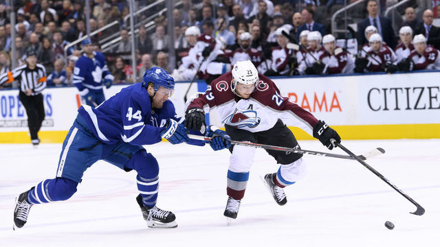 TORONTO, ON - JANUARY 14: Toronto Maple Leafs Defenceman Morgan Rielly (44) and Colorado Avalanche Center Nathan MacKinnon (29) reach for the puck during the first period of the NHL regular season game between the Colorado Avalanche and the Toronto Maple Leafs on January 14, 2019, at Scotiabank Arena in Toronto, ON, Canada.